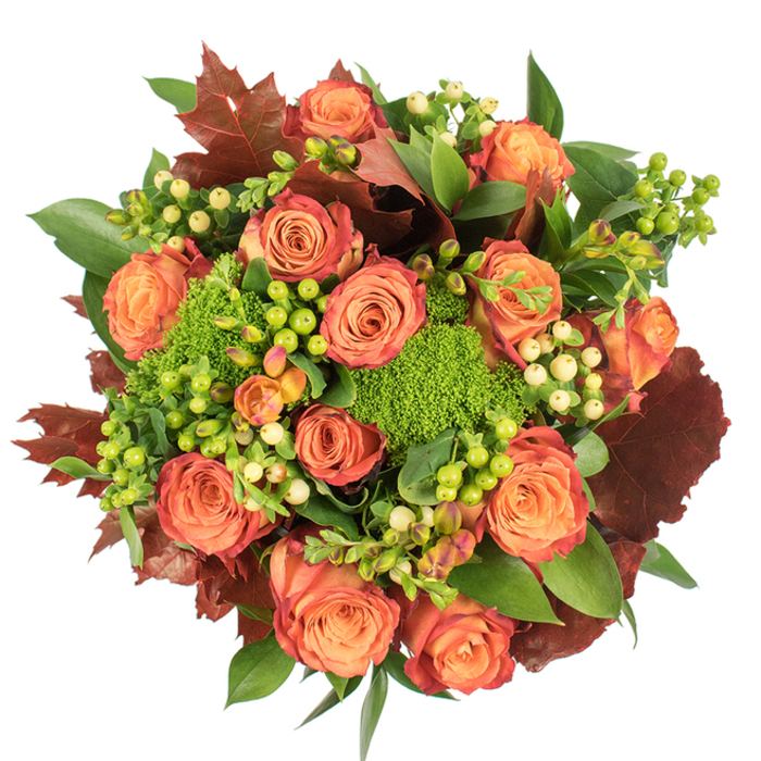 Viewed straight down, this bouquet reads as a compact study in autumnal colour and texture, expertly composed to feel both abundant and refined. A ring of large, fully bloomed roses dominates the scene: their inner petals retain a gentle peach glow while outer petals move through coral and burnished orange into russet and a subtle reddish-brown edge, giving each bloom a multi-tonal, hand-painted appearance. Interspersed among these are clusters of waxy Hypericum berries - some a zingy lime green, others a soft, creamy ivory - that add crisp punctuation and a jewel-like sheen. The eye rests on small, cushiony heads of Green Trick dianthus, which provide a velvety, almost sculptural green texture that contrasts with the smooth rose petals. Broad green leaves create a supportive backdrop, while larger, lobed leaves in deep burgundy and toasted brown are sprinkled through the composition to emphasize the season and offer visual weight.
The arrangement has a grounded, harvest-time character suited for a seasonal centerpiece or a thoughtful gift for someone near Kidbrooke or Horn Park. Light plays softly across the surfaces, highlighting velvety petals and glossy berries and casting gentle shadows that enhance the bouquet's dimensionality. There is an implied scent-scape here - the familiar sweetness of rose softened by green, earthy nuances from the dianthus and leaves - that invites touch and lingers in memory. The overall effect is warm, elegant and rooted in the colours of late autumn.