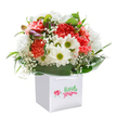 Infused with a quietly radiant joy, this carefully composed bouquet-displayed in a crisp white gift bag-embodies the freshness and skill for which Kidbrooke florists are known. Soft peachy carnations and vibrant reds unfurl in lush, textured abundance, their ruffled petals whispering of warmth and celebration. Nestled close, white daisies beam, their golden-lime centres bright with optimism, conjuring thoughts of sunlit picnics along Kidbrooke Green. Wisps of baby's breath dance between the bolder blooms, lending the arrangement a light, airy innocence, while hints of unopened, purple-tinged buds suggest new beginnings yet to unfold. Circled by a framework of deep green, glossy leaves that gather and reflect the ambient light, the bouquet is elevated-every stem chosen with expertise and care. The sturdy-handled bag positions the arrangement for effortless gifting, perfect for surprising someone special or marking a cherished occasion. Whether delivered by a local expert or given in person, this bouquet is the essence of thoughtful floristry in Kidbrooke: uplifting, fresh, and endlessly sincere.